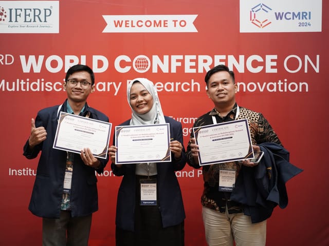 Three presenting authors holding certificates in front of the WCMRI conference backdrop