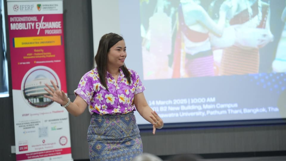 A presenter addressing delegates with her slides projected behind her